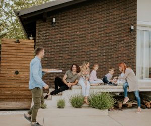 Happy group of young people and kids preparing for eating pizza in the house backyard